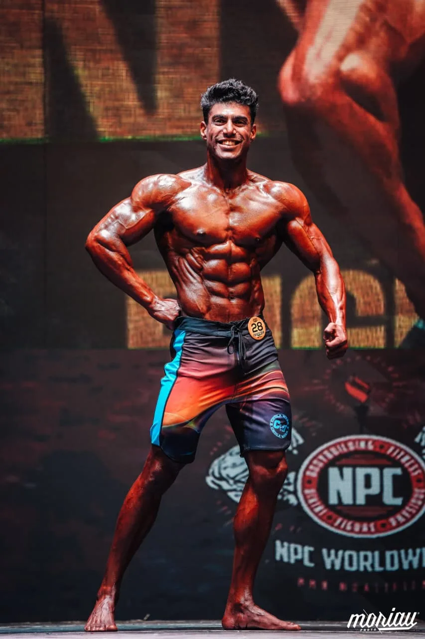 Zohaib Alam on stage in the men's physique line-up